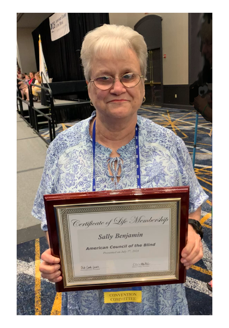 Sally Benjamin holding her Lifetime Membership award 